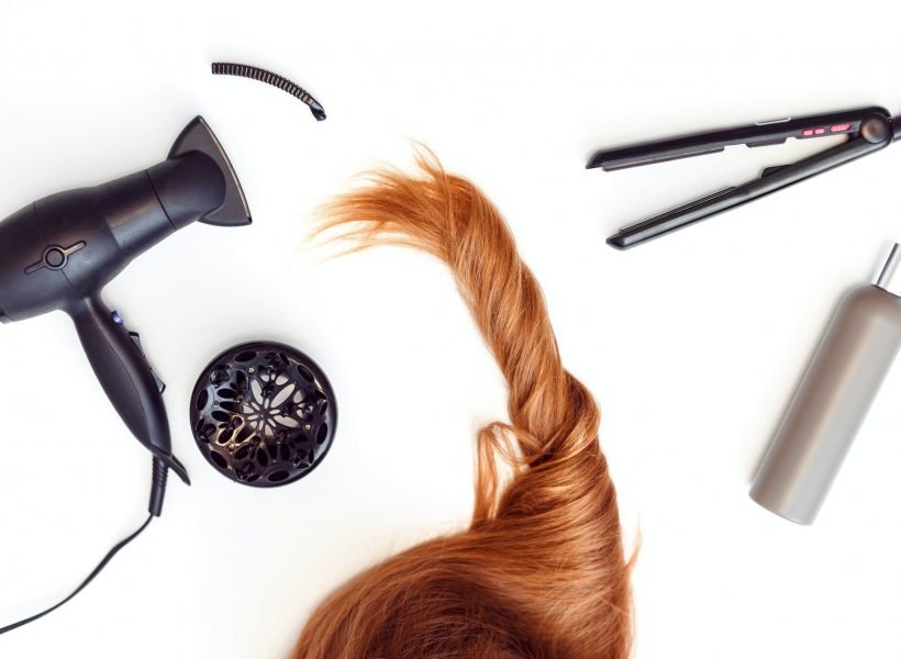 Set of tools dryer, iron and hair brush for hairstyle and red hair on white