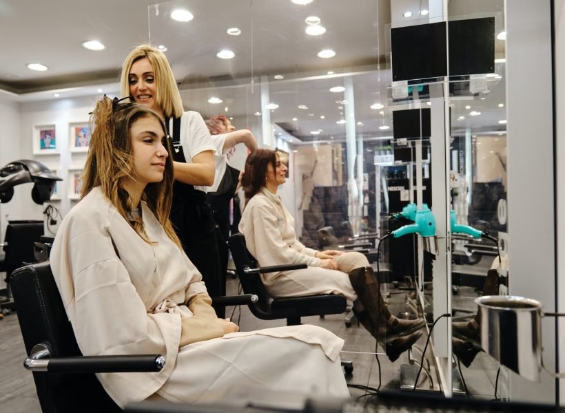 Women getting a hair styling by hairdressers at the beauty salon.